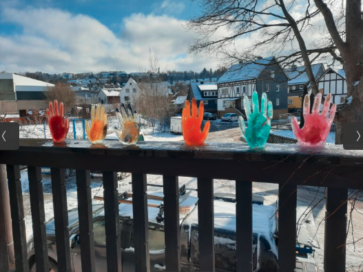 Children have filled up transparent rubber gloves with colored water and frozen it in the winter cold.